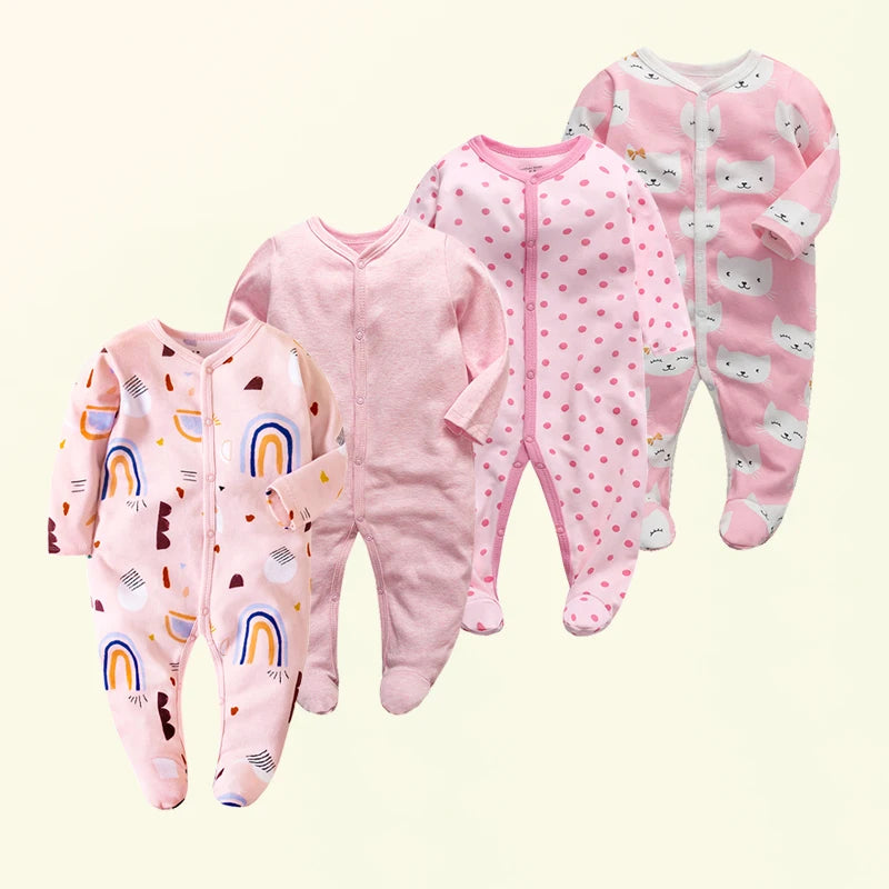 Four pink baby onesies with different patterns on a light beige background