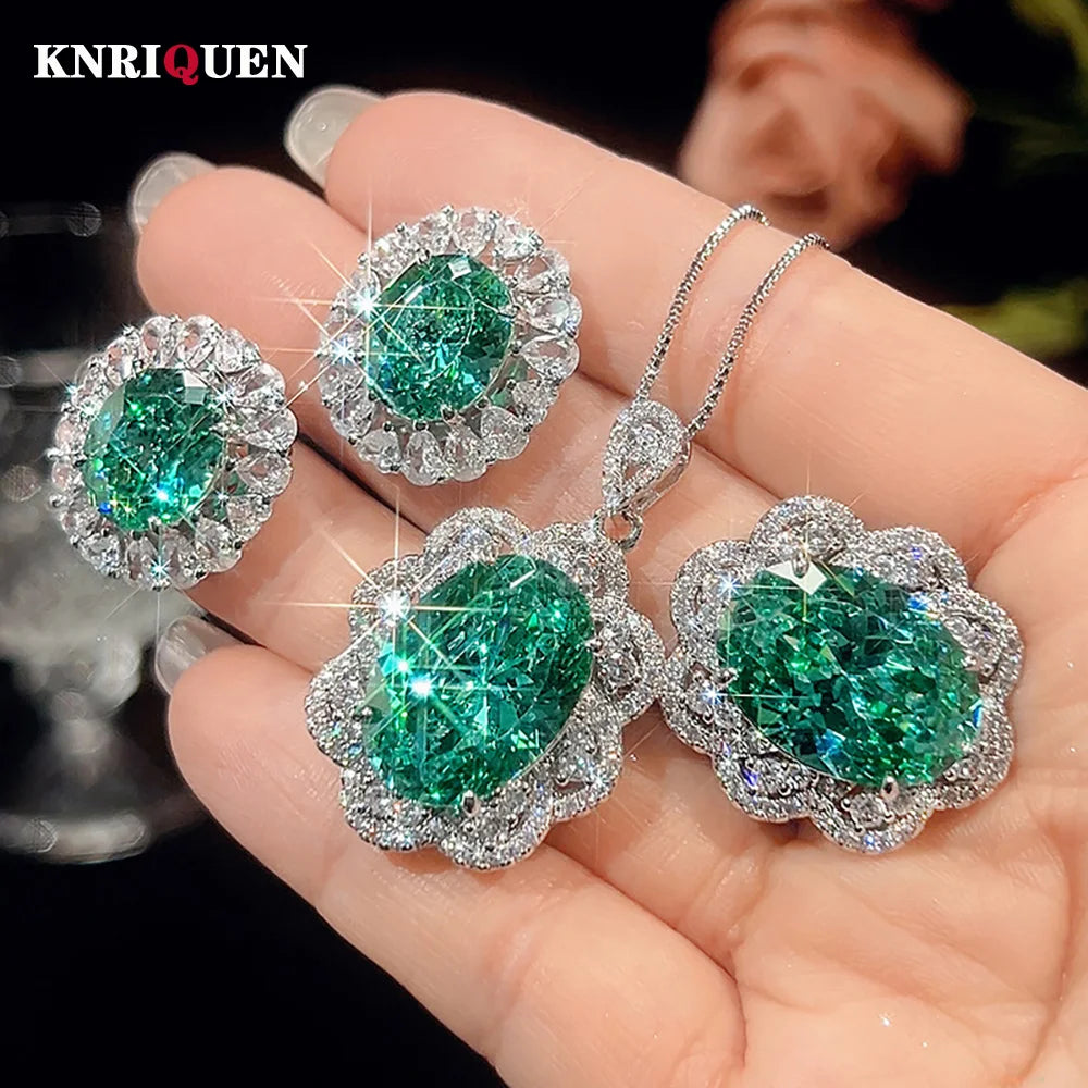 Emerald and diamond jewelry set held in a hand with 'KNRIQUEN' branding.