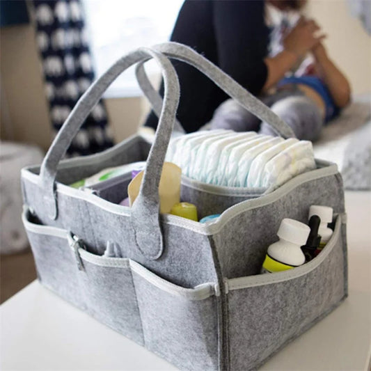 Gray storage caddy with baby items on a table